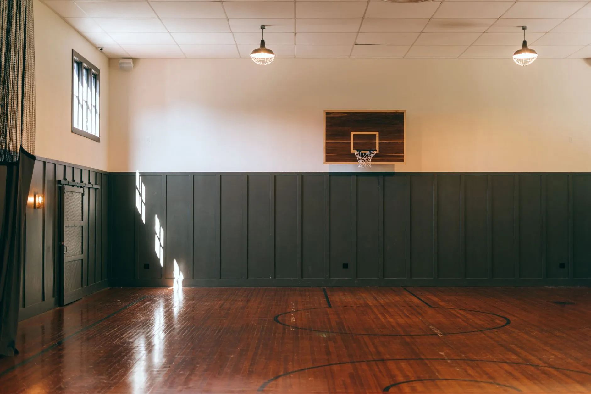 Pusta sala do koszykówki z drewnianym parkietem i koszem na ścianie