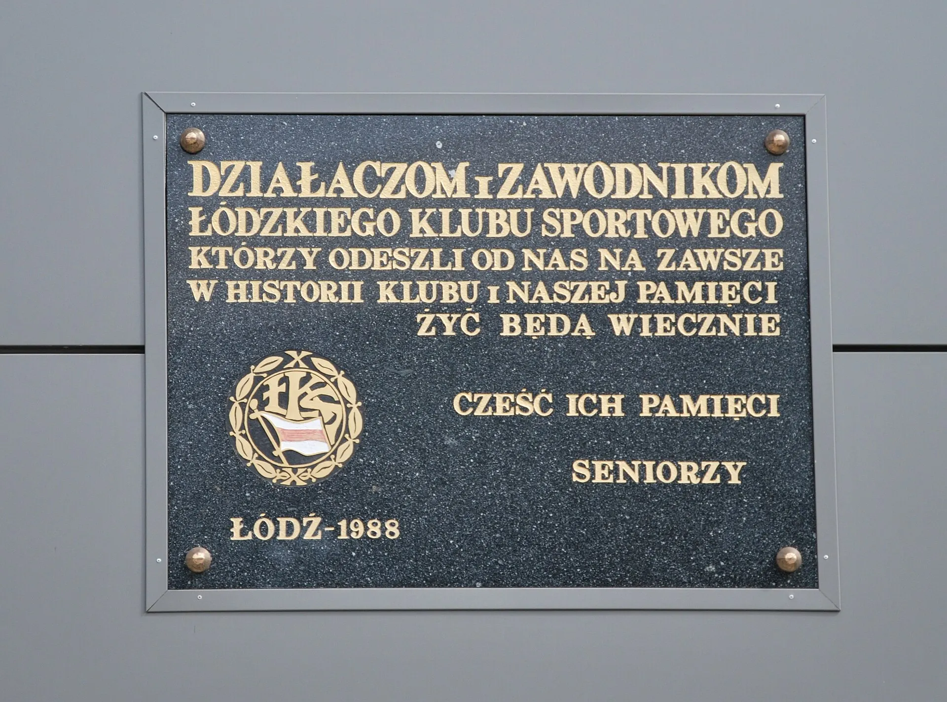 Tablica pamiątkowa na ścianie stadionu ŁKS Łódź w 2018 roku