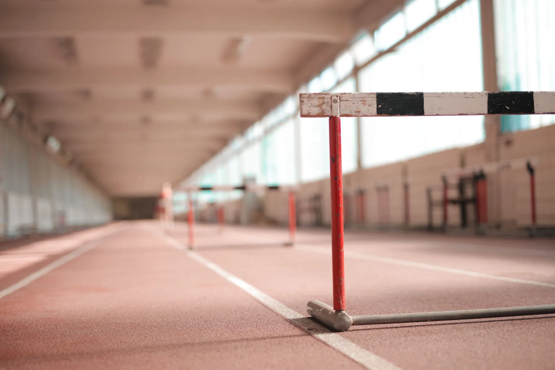 Płotek lekkoatletyczny na czerwonej bieżni w hali sportowej