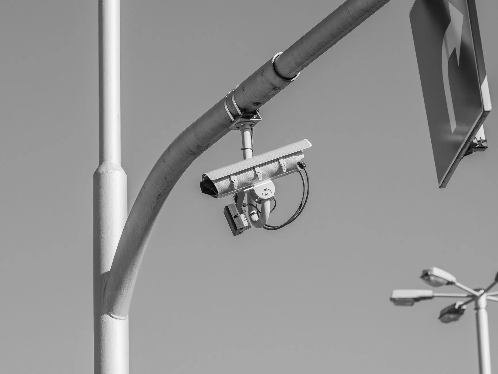 Kamera monitoringu zamontowana na metalowym wysięgniku nad ulicą
