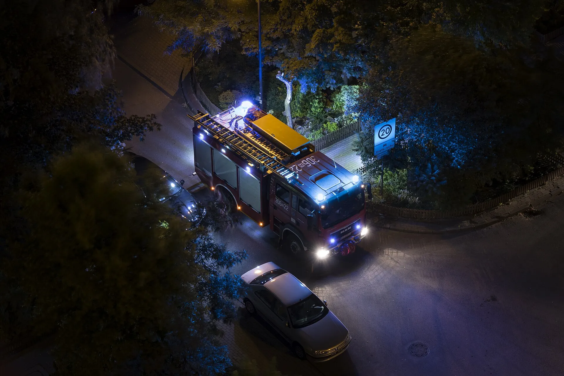 Wóz strażacki MAN nocą w Warszawie z włączonymi sygnałami