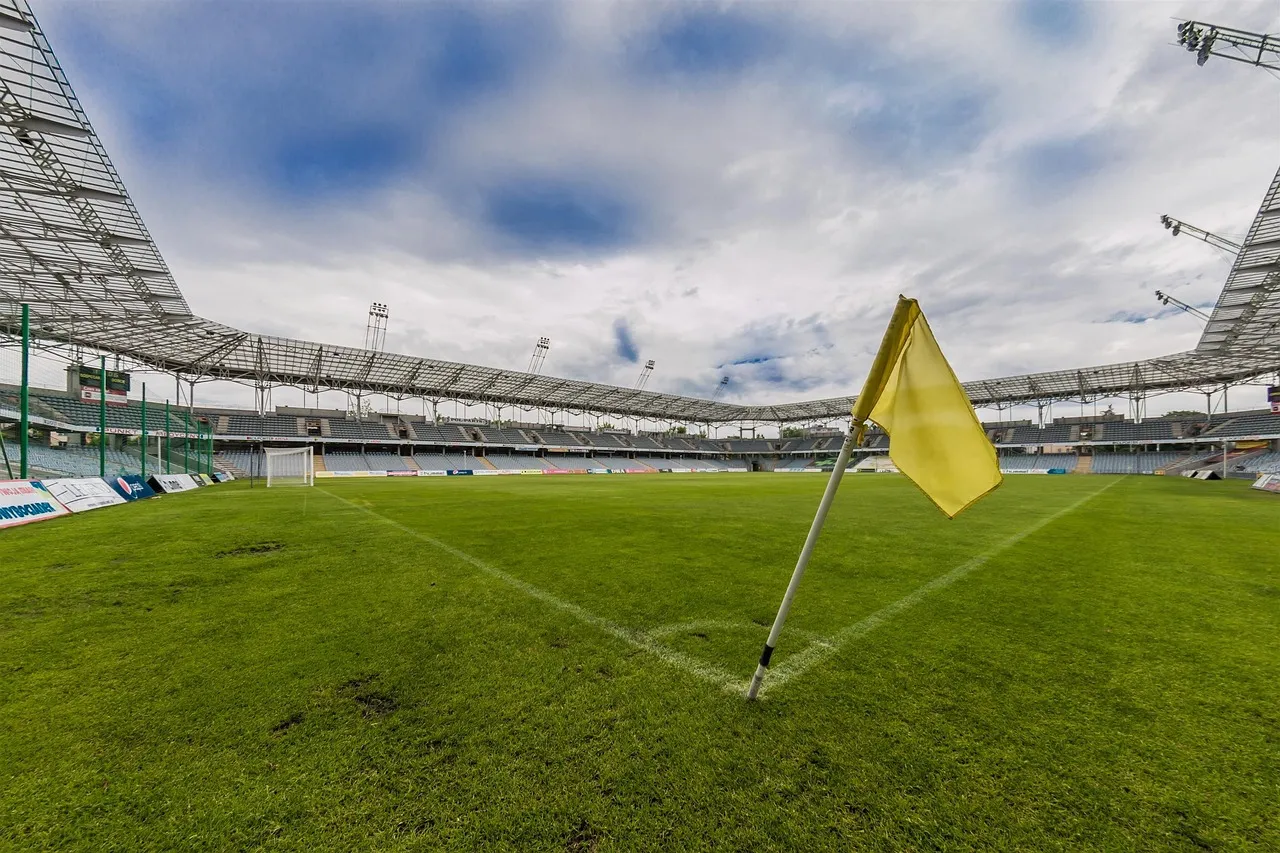 Puste boisko piłkarskie z żółtą chorągiewką narożną na stadionie