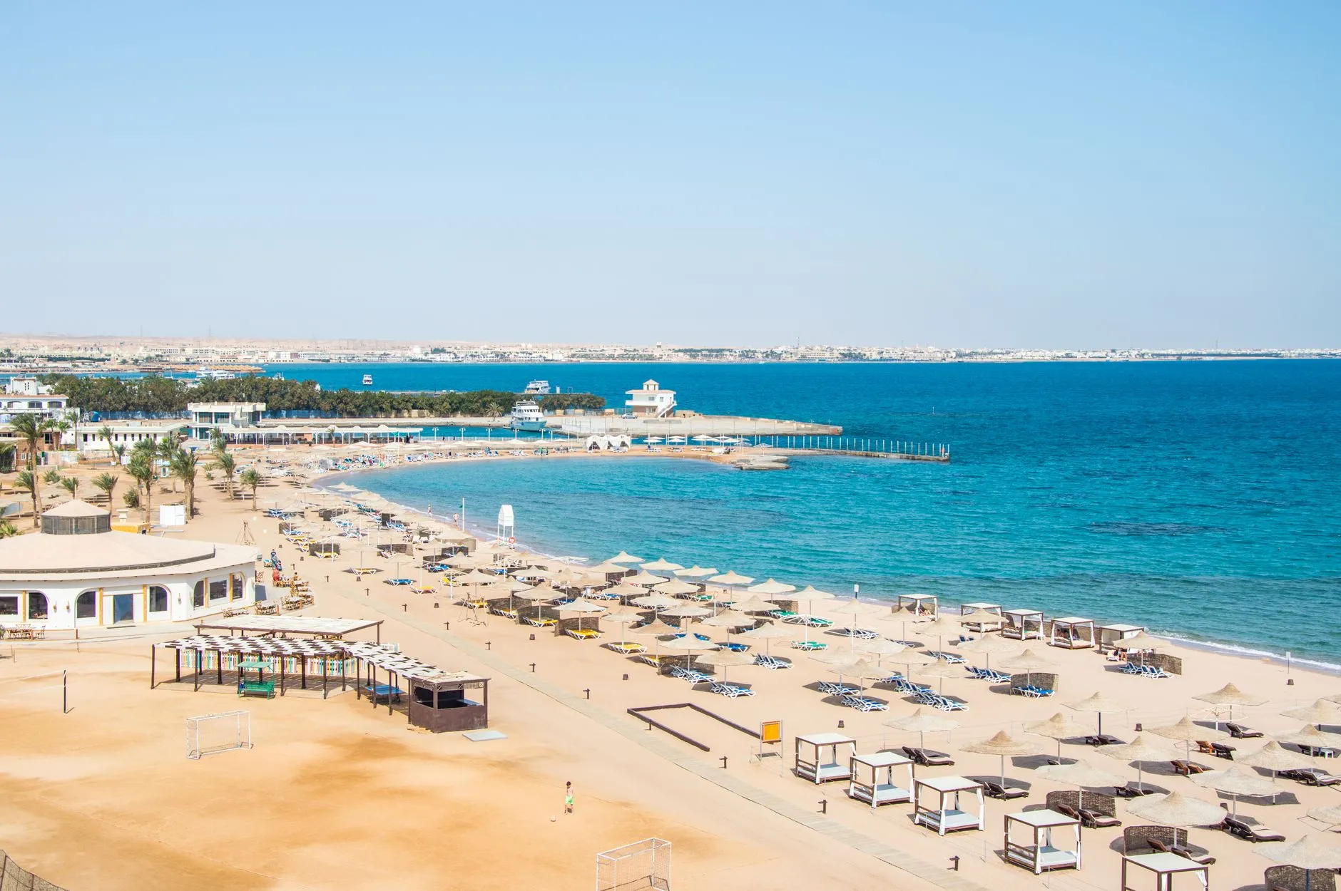 Piaszczysta plaża z parasolami i leżakami nad turkusowym morzem